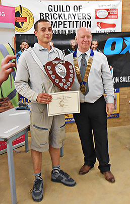 Guild of Bricklayers president, Kevin Harold, presents the London heat junior section winner’s shield to Zak Kharbough
