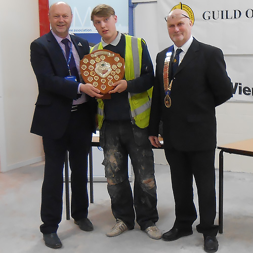 Kevin Burke, head of division, Preston College (left) and James Howe, president of the Guild Of Bricklayers (right), present Joe Higginson with his senior winner’s shield.