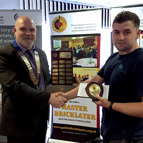 Guild of Bricklayers president, Phil Vine-Roberts, presents the award to Wales competition senior winner, Sean Howells from Bridgend College