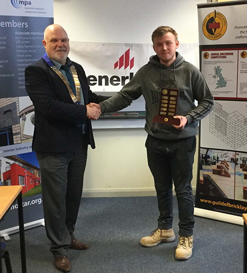 President of the Guild of Bricklayers, Phil Vine Roberts, presents Matthew Lloyd Hughes,Coleg Menai, with his trophy as winner of the junior section.